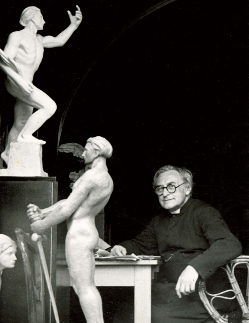 Cyriel Verschaeve aan het werk in zijn studio in Alveringem, omgeven door enkele van zijn martiale beeldhouwwerken, ca. 1938. (ADVN, VFAL333)