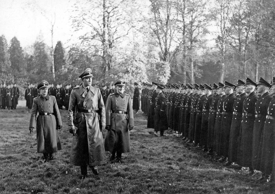 Richard Jungclaus (midden) vertegenwoordigt Himmlers SS in militair bezet België. Hier schouwt hij samen met hun leider Jef François (links) de troepen van de Algemene SS-Vlaanderen, s.d. (CegeSoma)