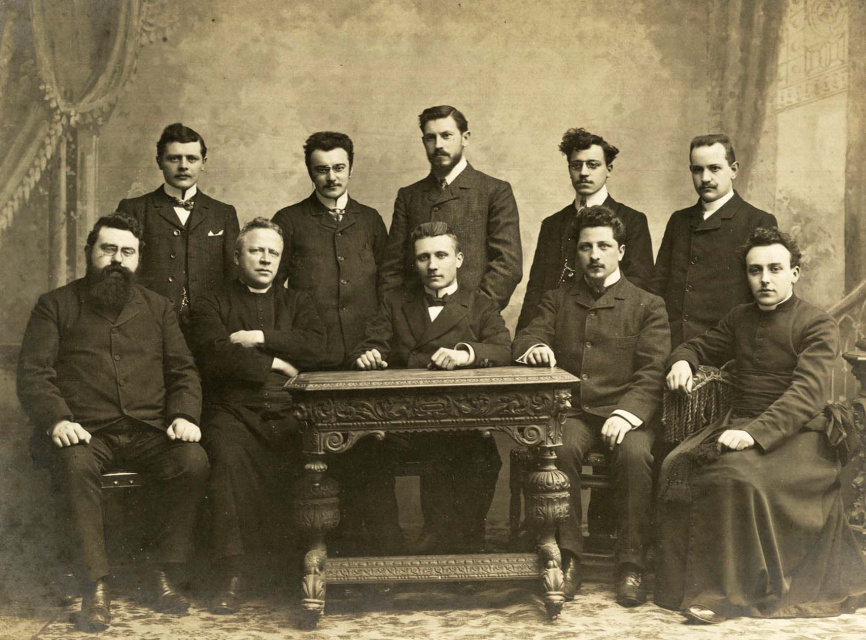 Bestuur van Met Tijd en Vlijt in 1904-1905. Van  links naar rechts (zittend): Jozef van den Eynde, Joseph Sencie, Emiel Vliebergh, Leo van Puyvelde, Hendrik de Vocht, (staand): Alfons Fierens, Gustaaf Doussy, Frans van Cauwelaert, Leo van der Essen, Jozef Indekeu. (KADOC, kfd000516)