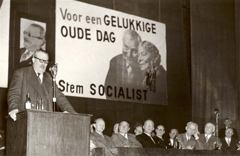 Toespraak van Achille van Acker naar aanleiding van de verkiezingen (thema sociale zekerheid), 31 mei 1954. Naast de spreker van links naar rechts onder anderen: Louis Major, Antoon Spinoy, Camille Huysmans en Jos van Eynde. (Amsab-ISG, fo011514)