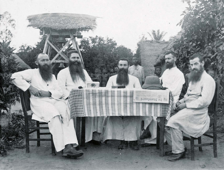 <p>Missionarissen van Scheut in Bokoro, jaren 1920. Op tafel ligt een exemplaar van de krant <em>De Standaard</em>. (KADOC)</p>