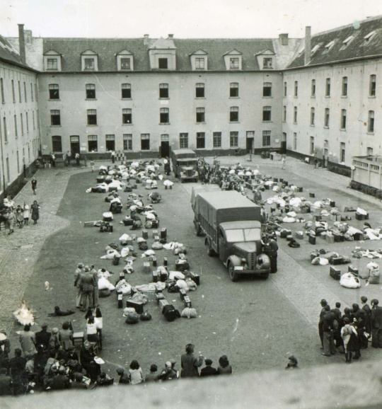 Aankomst van opgeroepen joden op de binnenplaats van Kazerne Dossin in Mechelen, ca. 27 juli 1942. Vanuit de Dossin-kazerne werden meer dan 25.000 Joodse mensen en 354 Roma en Sinti gedeporteerd naar Auschwitz-Birkenau. (Kazerne Dossin)