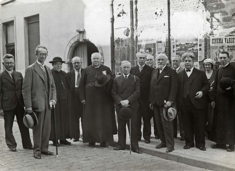 Leden van de Koninklijke Vlaamse Academie voor Taal- en Letterkunde na de plechtige zitting in Lier ter gelegenheid van de 100ste verjaardag van de geboorte van de letterkundige Tony Bergmann, 30 juni 1935. Van links naar rechts: Stijn Streuvels, Camille Huysmans, Jozef van Mierlo, Jan Grauls, deken Jozef Jacobs, Arthur Cornette, Maurits Sabbe, Jozef Cuvelier, Ferdinand Toussaint van Boelaere, onbekende, Emmanuel de Bom, Felix Timmermans, onbekende en Floris Prims. (Collectie Stad Antwerpen, Letterenhuis)