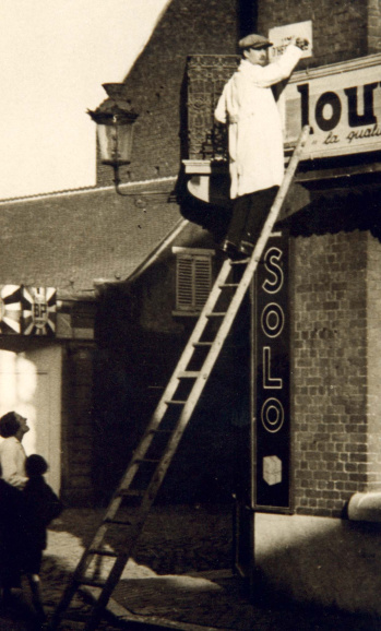 Flor Grammens overschildert een Franstalig straatnaambord, ca. 1937. (ADVN, VFB749)