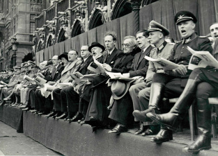 Het Vlaams Nationaal Zangfeest van 31 augustus 1941 op de Grote Markt van Brussel, met van links naar rechts: Renaat van Thillo, een onbekende, Jef van de Wiele, Cyriel Verschaeve, Rob van Roosbroeck, August Borms, Hendrik Elias en Victor Leemans tijdens het zingen van De Vlaamse Leeuw. (ADVN, VFAL122)