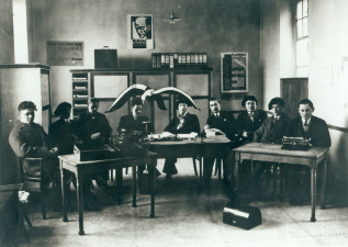 Het AKVS-hoofdbestuur 1929-1930 op het secretariaat te Leuven. Van links naar rechts: Theo Luykx, Karel de Vaster, Achiel de Gryse, Pol Heyns, Joris Geens, Joris Hermans, Walter Bouchery en Jos Leysen, onbekend. (ADVN, VFB1158)