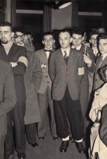 Bob Maes, leider van de Vlaamse Militanten Orde, staand tussen toehoorders op de slotvergadering van het eerste Volksuniecongres, Gent, 24 april 1955. (ADVN, VFA58/15)