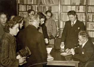 Ernest Claes tekent eigen werk in een boekhandel, Brussel, 27 december 1951. (ADVN, VFA5931)